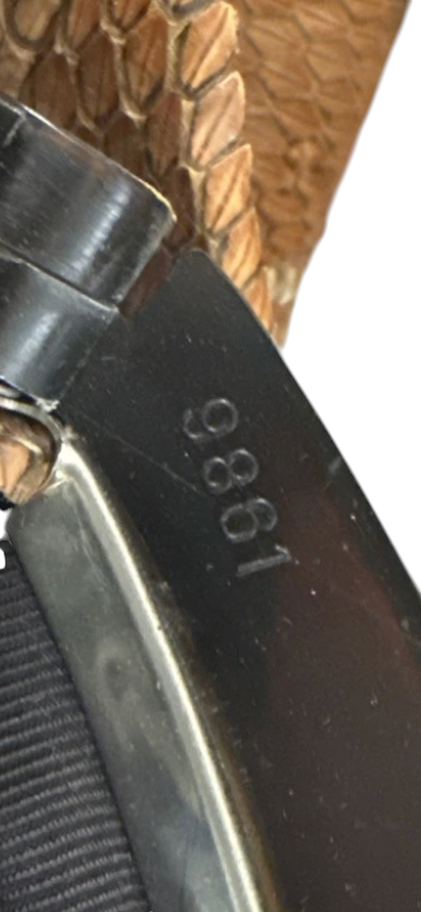 Recycle Me Fancy vintage snakeskin clutch frame detail with engraved number 9861 against brown exotic leather scales