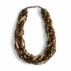 Recycle Me Fancy vintage multi-strand necklace featuring carved bone, amber glass, and black beads in a boho style.